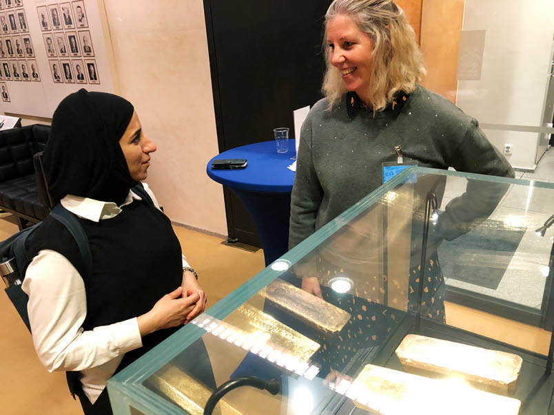 Hissa AlFarsi tittar på guldtackor och pratar med Riksbankens medarbetare Lena Strömberg.